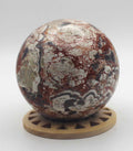 Polished money agate crystal sphere with red veining